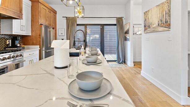 A modern kitchen with a marble island, stainless steel appliances, and a view to the outside. - Renovated home minutes from downtown Indianapolis! (Indianapolis)
