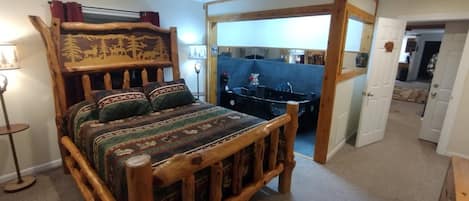 A wooden bed with a headboard, a bedside table, and a lamp.