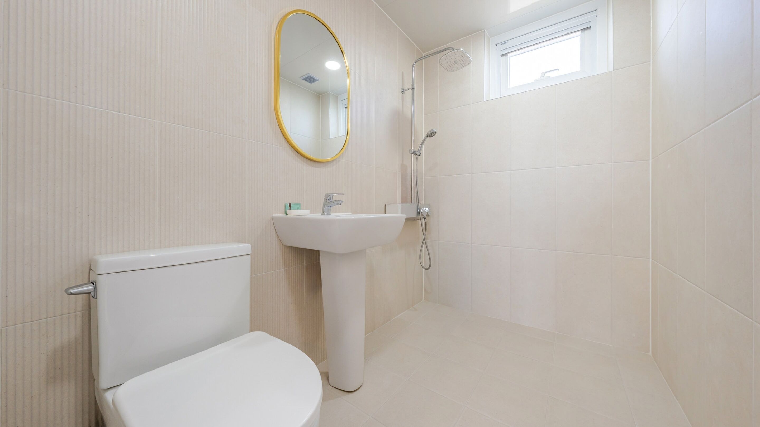 A bathroom with a toilet, sink, and shower.
