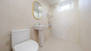 A bathroom with a toilet, sink, and shower.