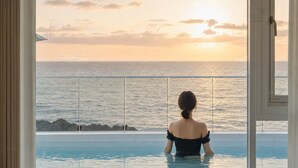A person in a pool with a view of the ocean and sunset. - Donghae Badadam Ocean View Spa Pension (Donghae)