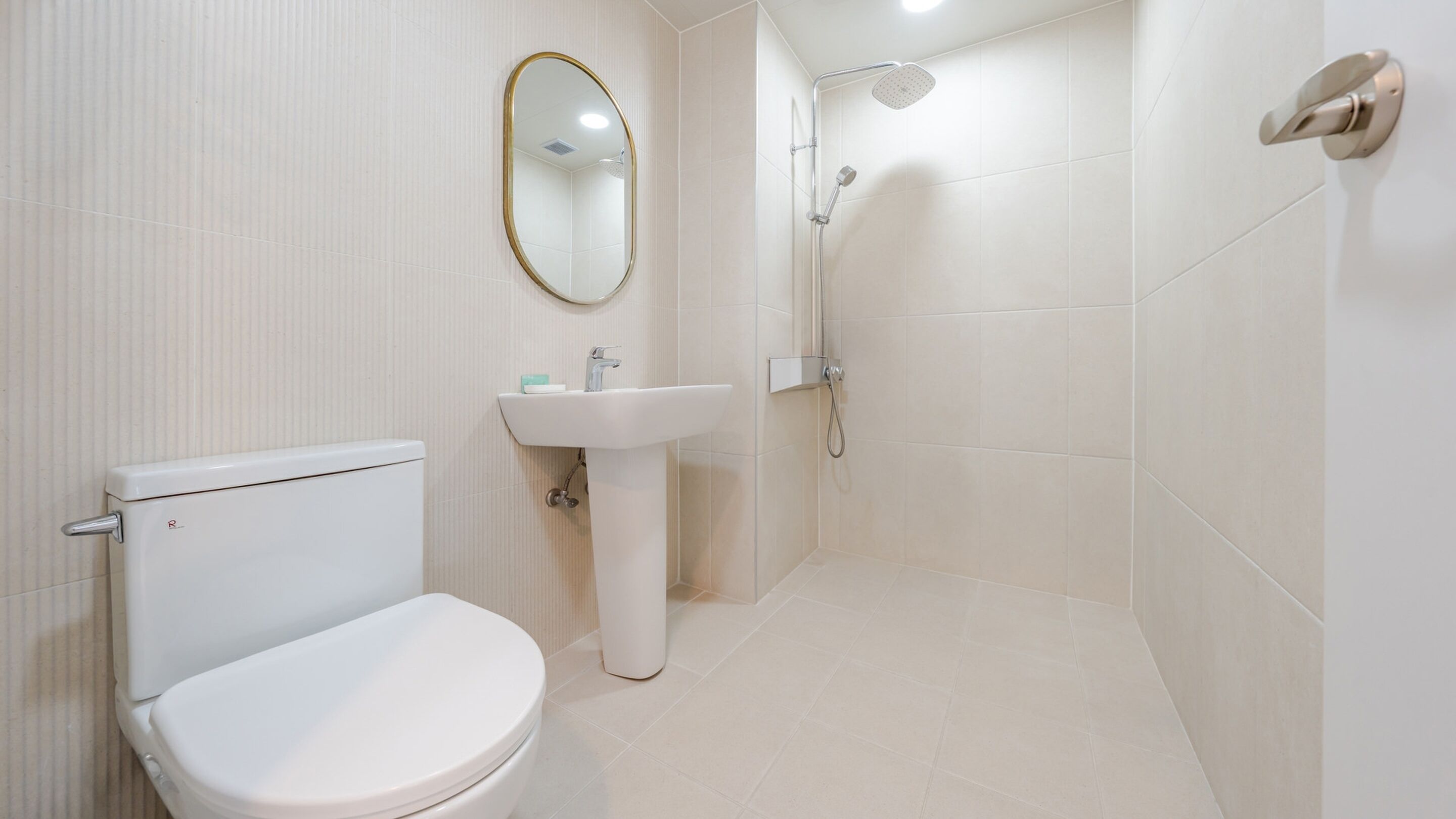 A bathroom with a toilet, sink, and shower.