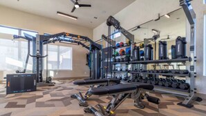 Une salle de sport équipée de matériel de musculation, d’un banc et d’haltères.