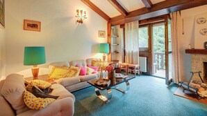 Una sala de estar con sofá, mesa de centro y chimenea.