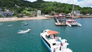 Un grand bateau était amarré à un quai, avec une plage et des bâtiments en arrière-plan.