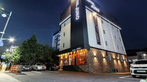 A hotel with a modern design, featuring a prominent sign and a brick facade. - HOTEL JUNO (Yongin)
