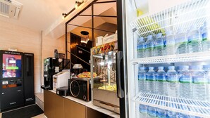 A self-service area with a card deck, popcorn machine, and a refrigerator stocked with water bottles. - HOTEL JUNO (Yongin)