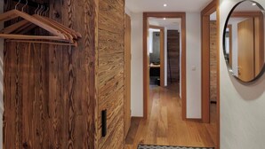 Ein Flur mit Holzvertäfelung, einer Holztür, einem Spiegel und einem Kleiderhaken.