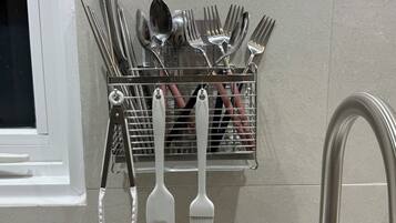 A kitchen utensil holder with various utensils like forks, spoons, and spatulas.
