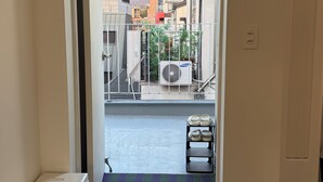 Une entrée d’immeuble donnant sur la rue, avec d’autres bâtiments visibles au loin.