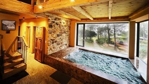 A spa area with a stone wall, wooden staircase, and a view of the outdoors. - Amaya Home Lodge, SPA & Restaurant (Hanoi)