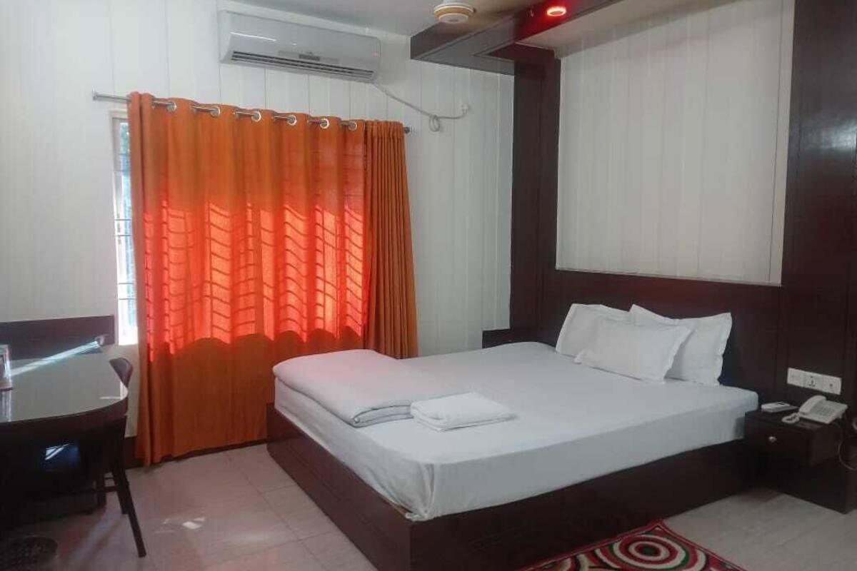 Ein Hotelzimmer mit Bett, Schreibtisch und Stuhl.