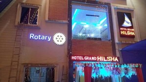 Un bâtiment sur lequel on peut voir une enseigne indiquant « Rotary » et « Hôtel Grand Hilsha ».