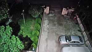 Un espace de stationnement avec deux voitures et une zone abritée.