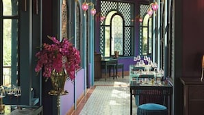 A room with a patterned floor, a chandelier, and a table set with glasses. - Riad Luxury Hotel Hanoi (Hanoi)