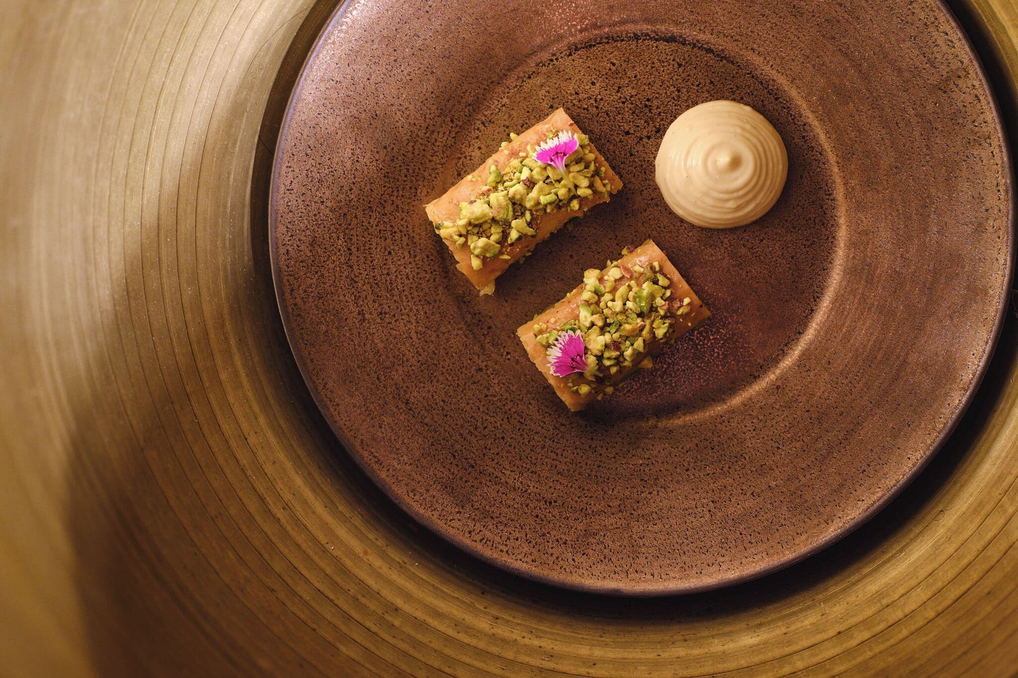 A plate with two pieces of food and a dollop of cream.