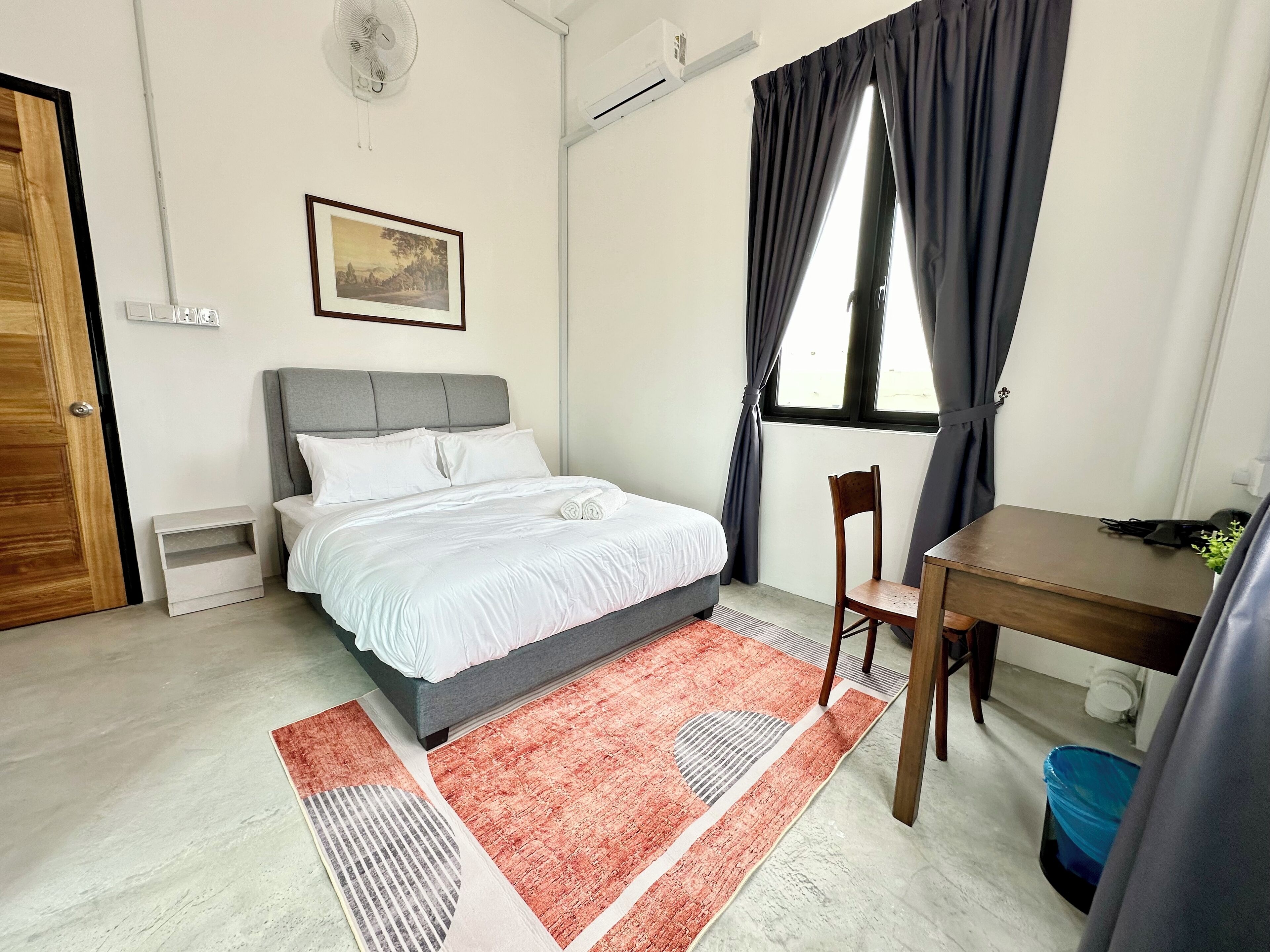 Ein ordentlich eingerichtetes Schlafzimmer mit Bett, Schreibtisch und Stuhl.