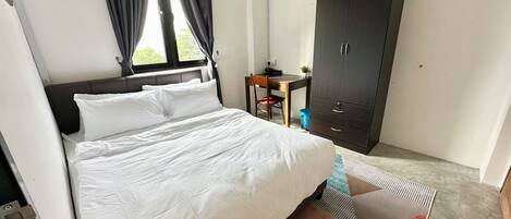 Una habitación de hotel con cama, armario, escritorio y ventana con cortinas.