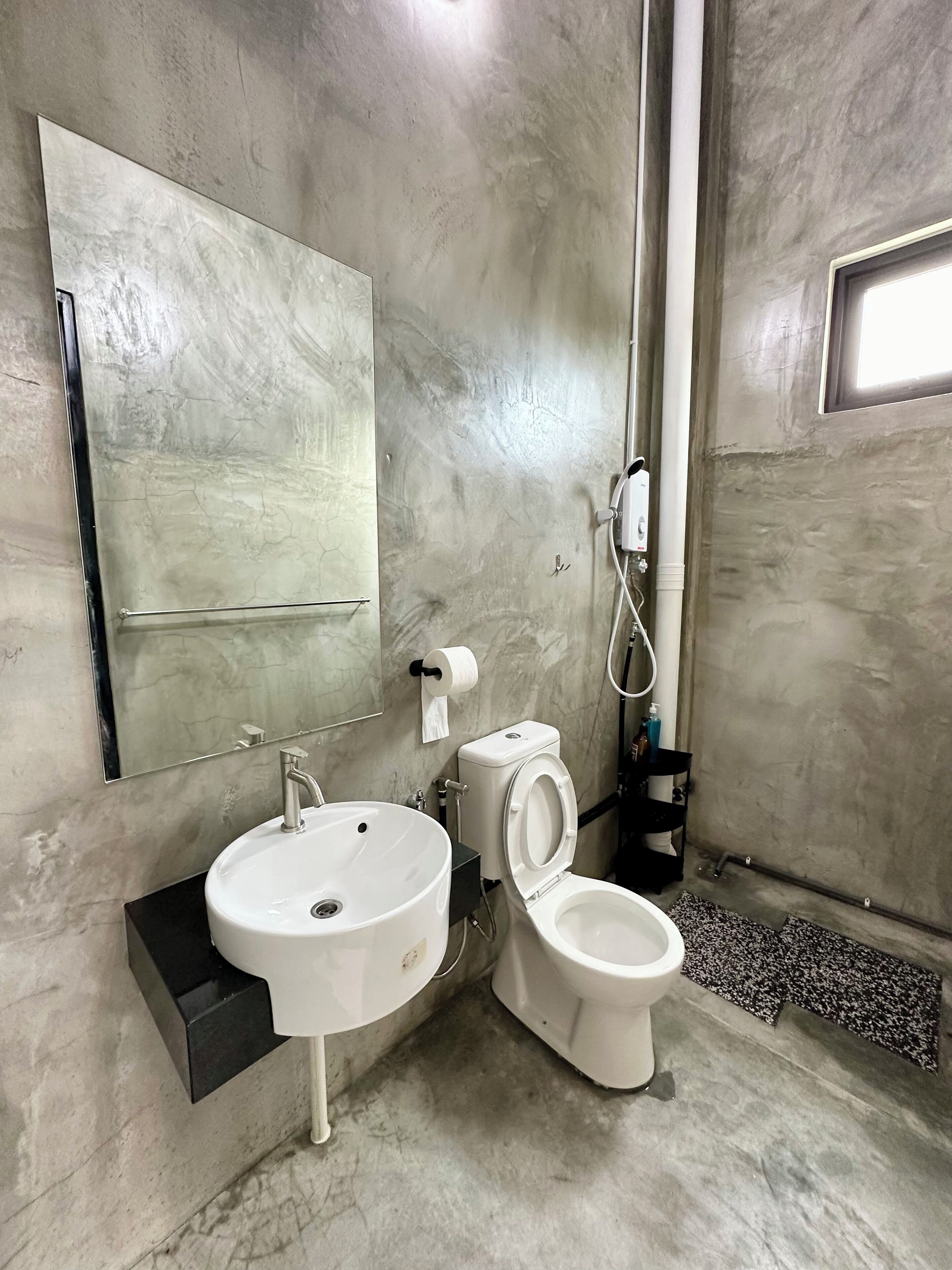 Un baño con lavabo, inodoro y espejo.
