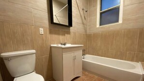 A bathroom with a toilet, sink, and bathtub. - Delightful 3-bedroom apartment in Montréal perfect for your stay (Montréal)