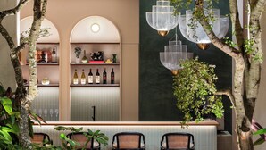 A bar area with a modern design, featuring a bar counter, seating, and hanging pendant lights. - Cheong Fatt Tze - The Qing Suites (George Town)