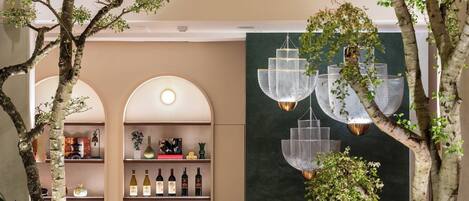 Zona de bar con diseño moderno, que incluye barra, asientos e iluminación colgante.