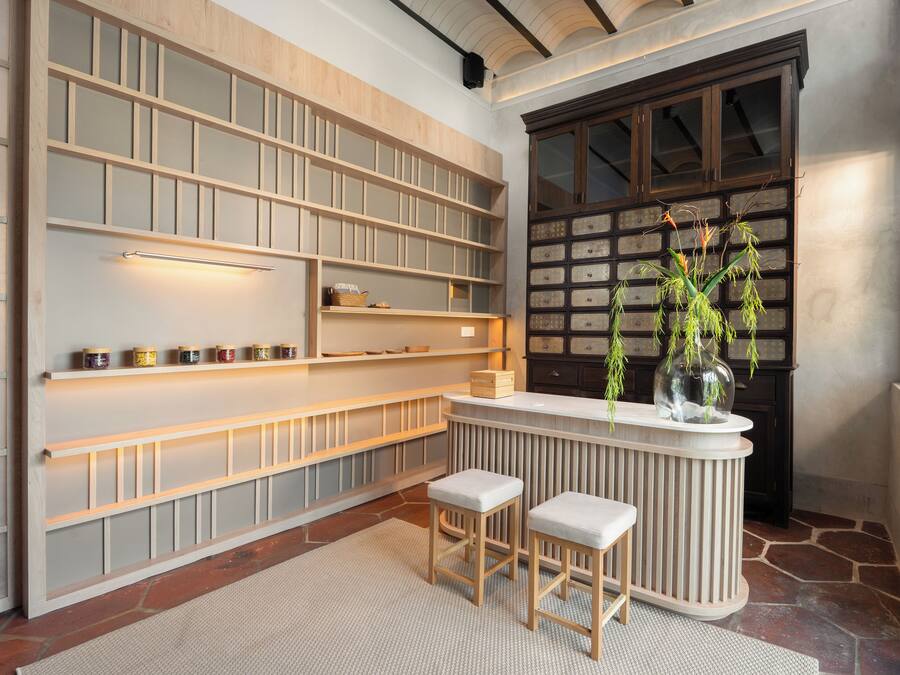 A modern kitchen with built-in shelves, a bar area, and a stone floor.