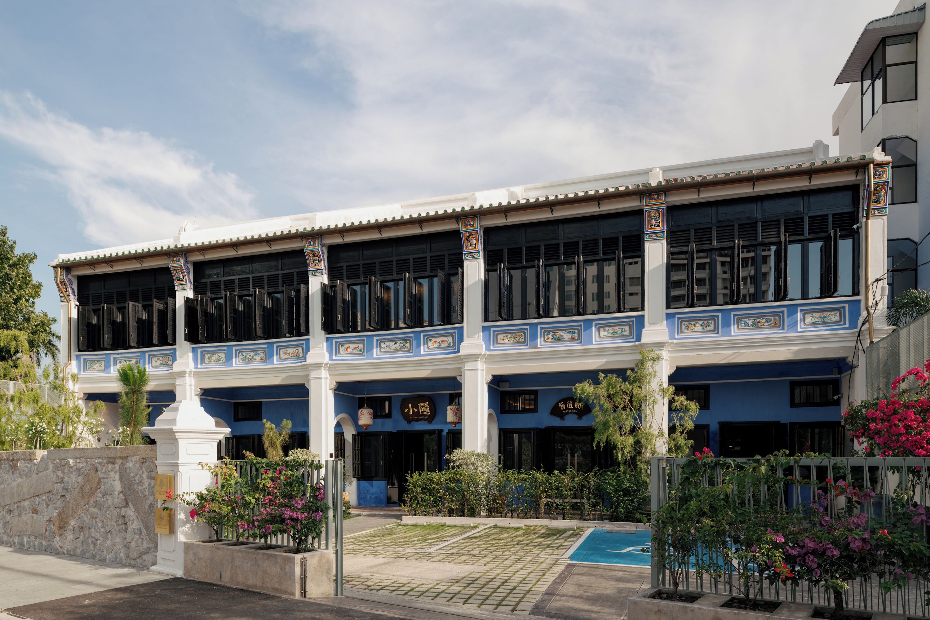 Un bâtiment traditionnel doté de nombreuses fenêtres et d’une entrée carrelée.