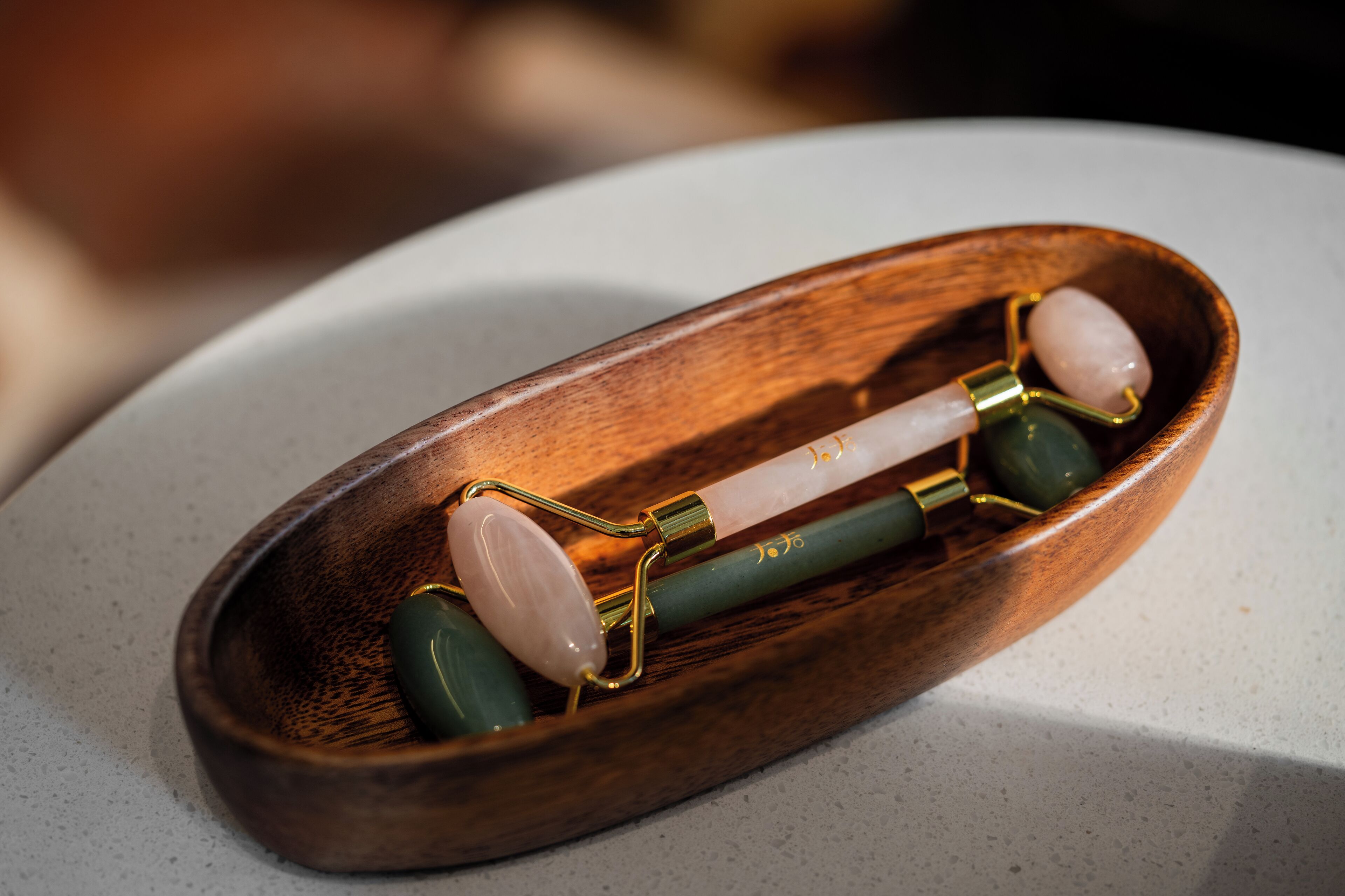 Ein Holz-Massagegerät mit Jade-Steinen und einem Metallgriff.