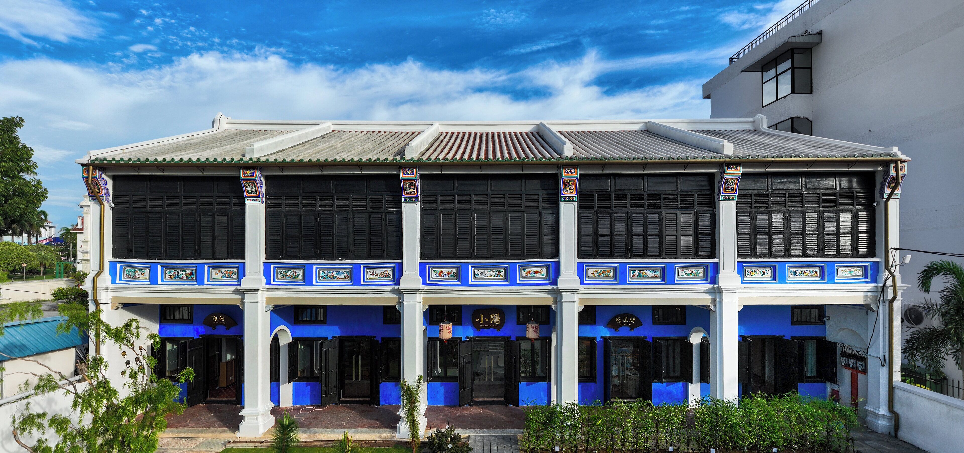 A two-story colonial-style building with a balcony, large windows, and traditional decorative elements.