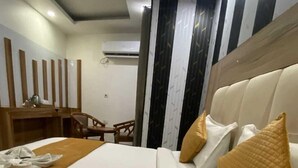 Een hotelkamer met een groot bed, een houten bureau en een stoel.