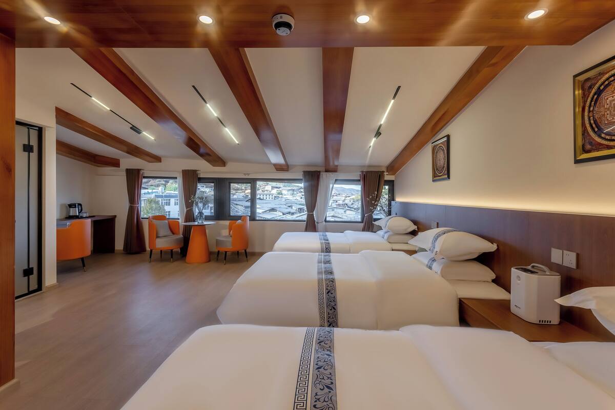Una habitación de hotel con tres camas, un escritorio y una silla.