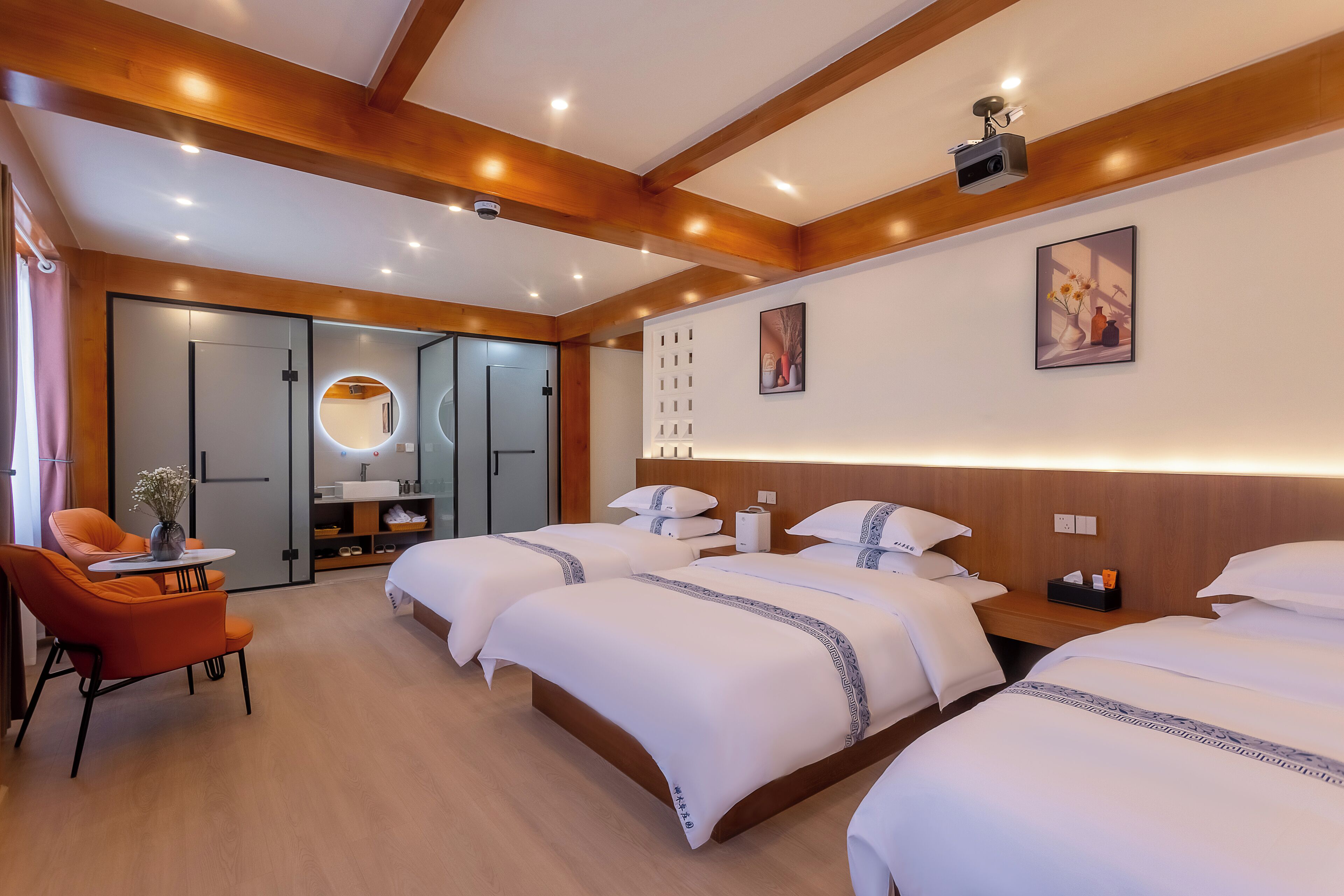 A hotel room with three beds, a wooden ceiling, a round mirror, and a small table with a vase.