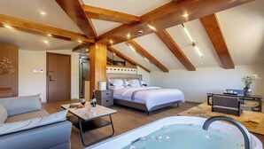 Un dormitorio moderno con una cama grande, un sofá, un escritorio y una bañera.