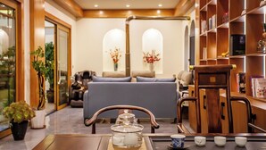 Una habitación acogedora con una mesa de madera, un sofá y una estantería.