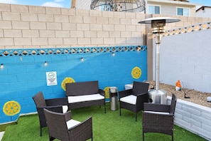Eine Terrasse mit Gartenmöbeln und einer Zierwand.