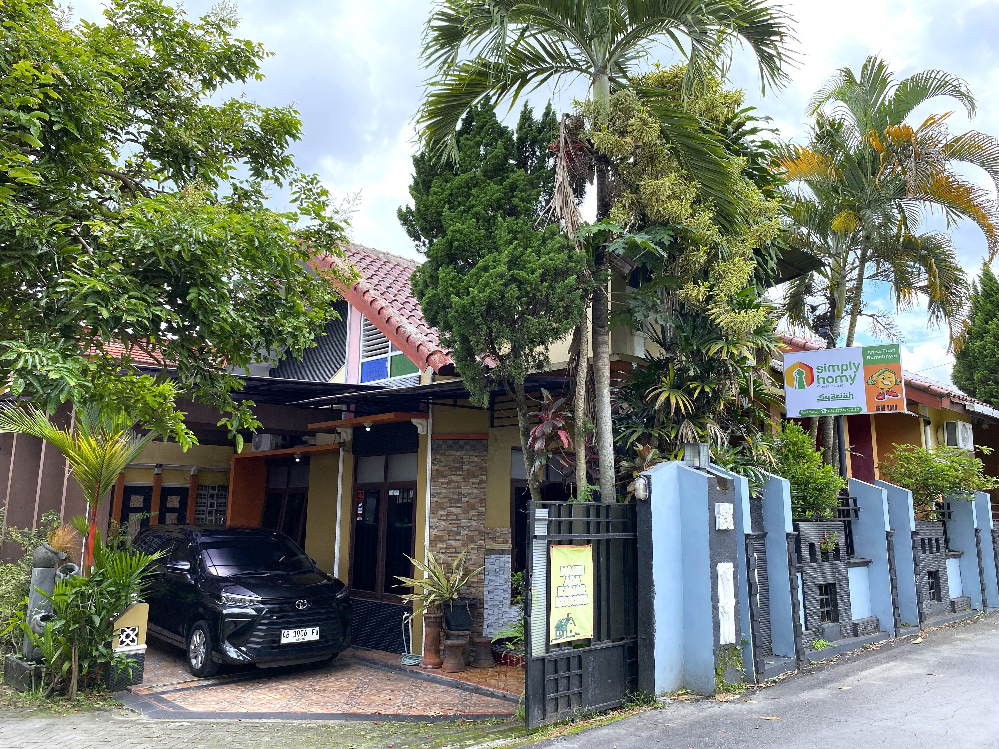 A building with a tiled roof, a gated entrance, and a parked car.