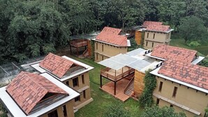 Un conjunto de edificios con techos de tejas rojas, rodeados de vegetación.