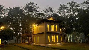 A two-story building with multiple windows and a balcony, surrounded by trees. - Matir Maya Eco Resort Gazipur (Sreepur)