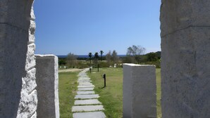 Un sentier de pierres mène à un point de vue sur l’océan, encadré par une arche en pierre.