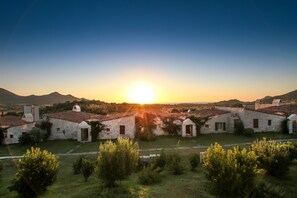 A row of stone buildings with a clear view of the sunset in the background. - Li Conchi 44 – Dream Villa Surrounded by Nature Near Pool and Beach (Castiadas)