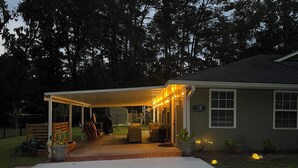 A covered patio area with outdoor seating, a barbecue grill, and string lights. - The Cardinal House 1B in charming Savannah (Savannah)