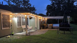 A covered patio area with string lights, outdoor furniture, and a grill. - The Cardinal House 1B in charming Savannah (Savannah)