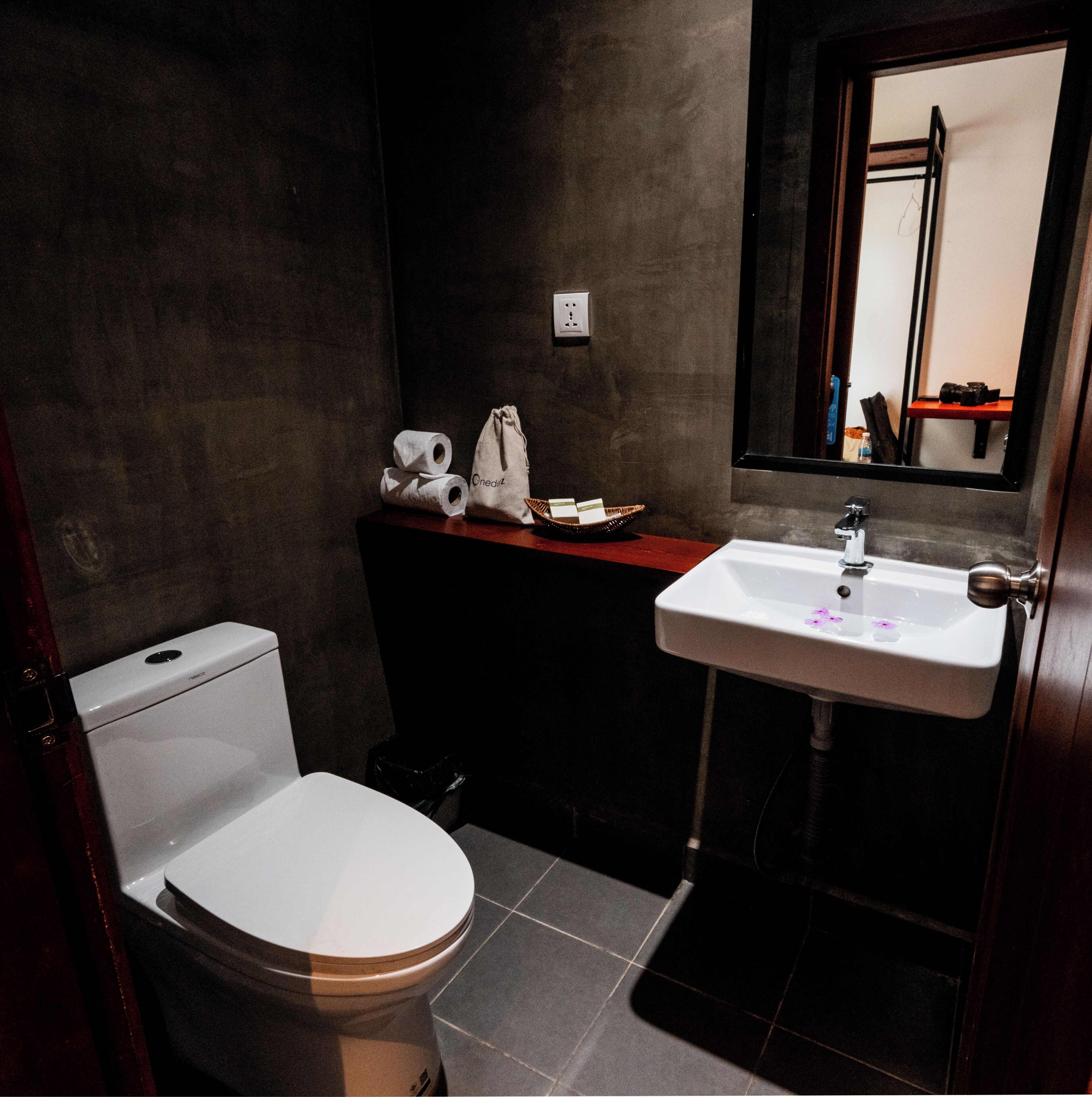A small bathroom with a toilet, sink, and mirror.