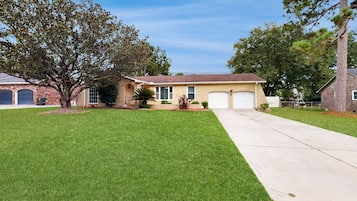 A two-story house with a front yard, a driveway, and a garage.