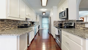 A kitchen with white cabinets, granite countertops, and a tiled backsplash. - Bring Your Pup! Goose Creek Home w/ Private Pool (Goose Creek)