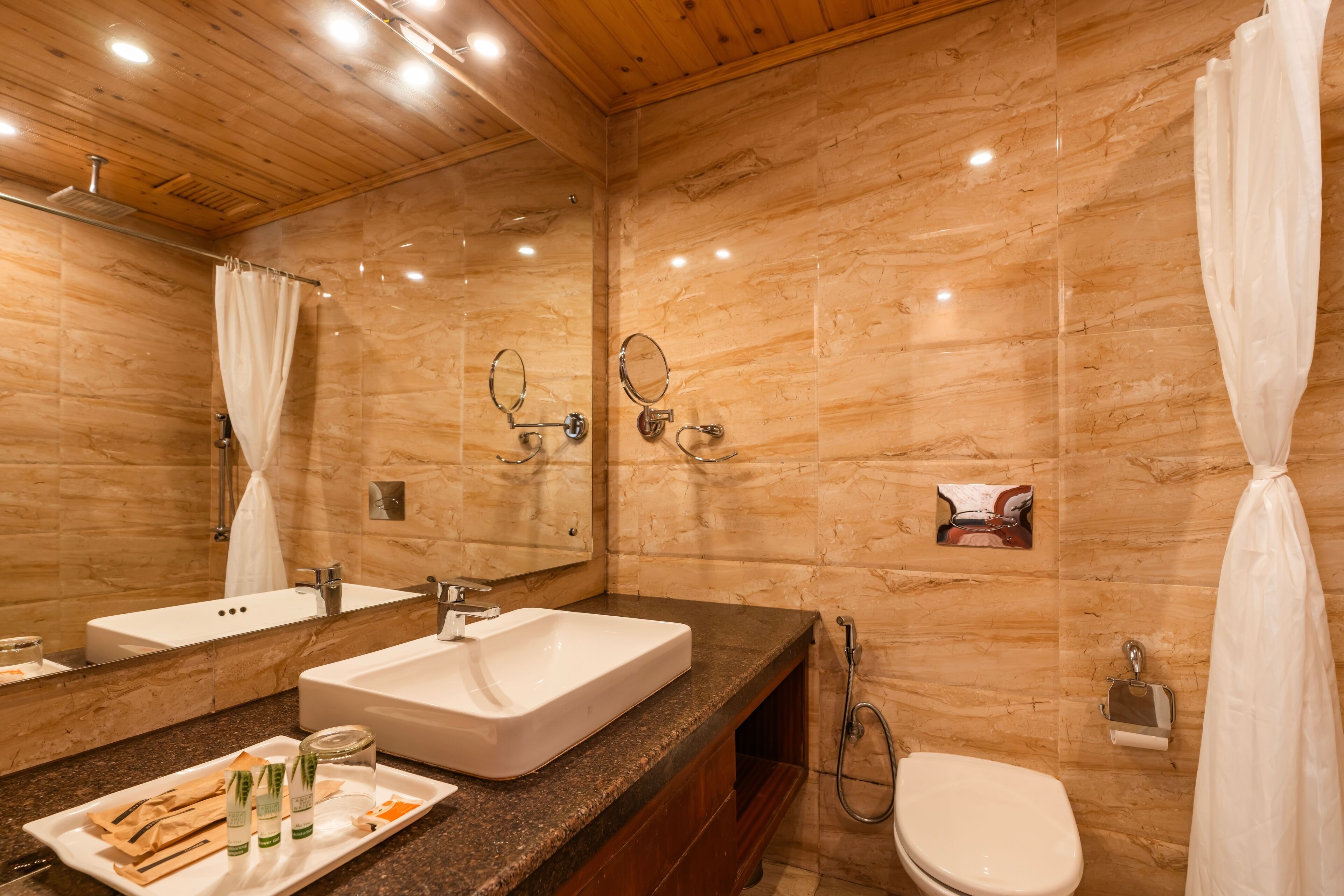 A bathroom with two sinks, a toilet, and a shower.