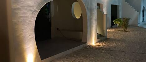 Un edificio moderno con aberturas arqueadas y una escalera que lleva a un nivel superior.
