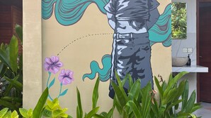 Un mural muestra a un niño con olas en un edificio.
