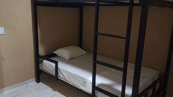 A bunk bed room with a tiled floor and beige walls.